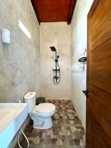 a bathroom with a toilet and a sink at The Griya Masz Guesthouse 2 in Kuta Lombok +11 photos