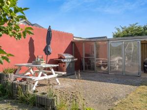 a patio with a table and an umbrella and a grill at Holiday Home Blaguna - 900m from the sea by Interhome in Hirtshals +18 photos