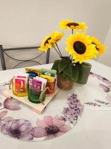 a table with a vase of sunflowers and a basket of candles at Casetta la Bruna in Naples