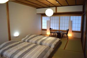 a bedroom with a bed and a table with chairs at 飛騨棲家 花里 憩 Hidasumika Hanasato Ikoi in Takayama