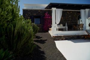 a house with a patio with chairs and plants at UNIQUE Homes Lajares - adults only in Lajares