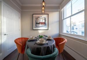 a dining room with a table and chairs and a window at Huge Town Centre 2 Bed Flat with Free Parking in Royal Tunbridge Wells