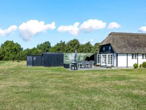a barn with a table and chairs in a field at Apartment Ronja - 1-3km from the sea by Interhome in Læsø +17 photos