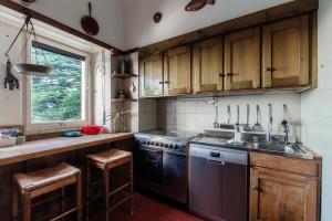 cocina con armarios de madera, fregadero y fogones en Almost Paradise by Quokka 360 - flat with a view of Lake Como, en Brunate