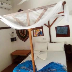 a bed with a canopy in a room at NEW ORANGE APARTMEnt in Jambiani