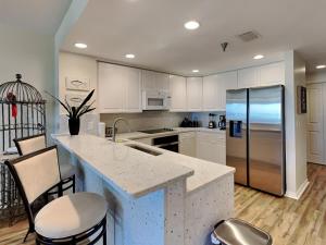 a kitchen with a counter and a refrigerator in it at Emerald Isle #106 in Pensacola Beach +21 photos