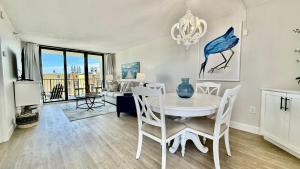a dining room with a white table and chairs at Top-floor ocean view condo with a private balcony and beachfront pool in Edgewater
