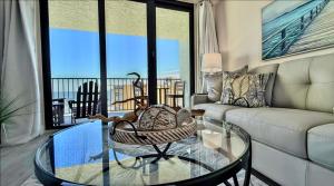 a living room with a couch and a glass table at Top-floor ocean view condo with a private balcony and beachfront pool in Edgewater