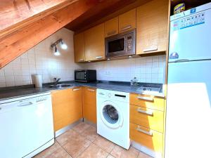 una cucina con lavatrice e microonde di Apartament bonic i amb altell a Esterri by RURAL D'ÀNEU a Esterri d'Àneu Altre 5 foto