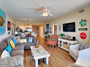 a living room with a couch and a tv at Emerald Isle #106 in Pensacola Beach