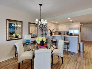 a dining room and kitchen with a table and chairs at Emerald Isle #106 in Pensacola Beach