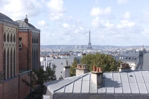 a view of the eiffel tower from the roofs of buildings at Hôtel Regyn's Montmartre in Paris