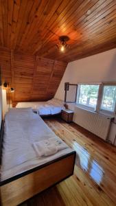 a bedroom with two beds and a wooden ceiling at Vila Lika in Zlatibor +11 photos