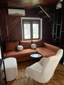 a living room with a couch and two chairs at Vila Lika in Zlatibor