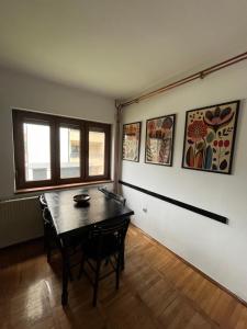 a room with a table and some paintings on the wall at Vila Lika in Zlatibor