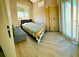 a bedroom with a bed and a chair and a window at Belek Holiday Villas-1 in Belek +9 photos