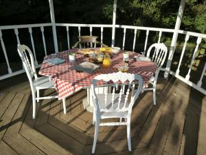 una mesa y sillas en una terraza con mesa y sillas en Le clos des oiseaux, en Maisnières