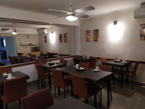 a restaurant with tables and chairs in a room at Hotel Mitre in Rosario