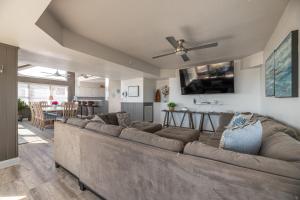 a living room with a large couch and a kitchen at Pier House - K1009, Unique Oceanfront Retreat in Nags Head, Indoor Pool! in Whalebone
