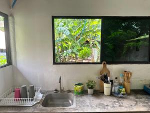 a kitchen counter with a sink and a window at Surfcity Townhouse in La Libertad