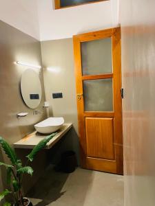 a bathroom with a sink and a wooden door at Leema hiriketiya in Nilwella +106 photos
