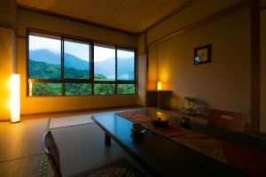 uma sala de estar com uma mesa e uma grande janela em Tashiro Annex em Yakushima
