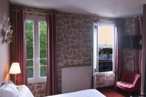 a bedroom with a bed and a chair and windows at Hôtel Regyn's Montmartre in Paris