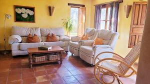 a living room with two couches and a table at Cortijo El Potro in Órgiva