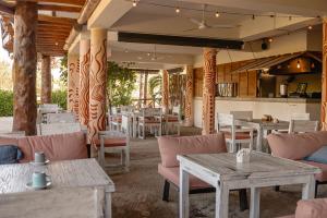 Casa Astral Hotel Boutique and Apartments في جزيرة هول بوكس: مطعم مع طاولات وكراسي ومطبخ