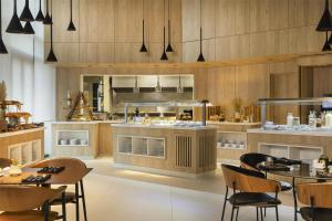 a restaurant with tables and chairs and a kitchen at Radisson Hotel Tunis, City Center in Tunis