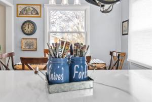 a table with two blue canisters filled with pens at True Bed - and Breakfast! - made fresh by Grandma in Frankenmuth