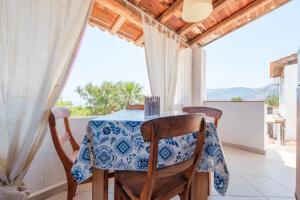 a dining room with a table and chairs on a balcony at JERA Holiday Collection VULCANO TRE - Sea View in Vulcano