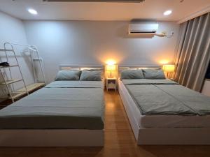 two beds in a room with two lights on at Sol Stay Seoul Hongdae in Seoul