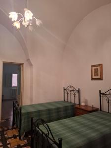 a bedroom with two beds and a chandelier at Casa Teresina in Cannole