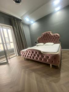 a bedroom with a pink bed in a room at Новая квартира с 1 спальней в ЖК Nexpo City - район Экспо, торгово-развлекательный центр MEGA Silk Way, Invictus GO, Назарбаев Университет, недалеко Ботанический Сад, аэропорт in Astana