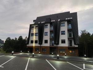 a building with a parking lot in front of it at WOLF apartman in Divčibare