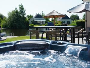 a plunge pool in a backyard with a table at Holiday Home Lieskehuis Wellness de Luxe 10-2 by Interhome in Vlagtwedde