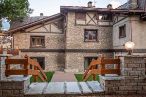 two wooden chairs sitting in front of a building at Hotel K2 in Sauze dʼOulx