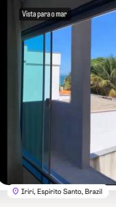 a glass door with a view of a building at Casa para temporada Balneário de IRIRI Espírito Santo ES in Iriri