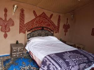 RhessouaneDoor sahara的卧室里有一张带木质床头板的床