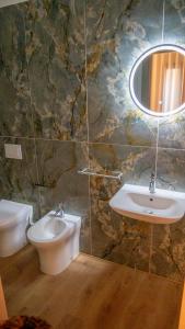 a bathroom with a sink and a toilet and a mirror at Ludey B&B Reggio Calabria in Reggio Calabria +26 photos