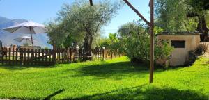 a wooden fence with an umbrella in a yard at Cortijo El Potro in Órgiva