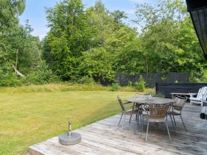 una terraza de madera con mesa y sillas en un patio en Holiday Home Josef - 1-4km from the sea by Interhome, en Rørvig