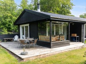 Una casa negra con una terraza con mesa y sillas. en Holiday Home Josef - 1-4km from the sea by Interhome, en Rørvig 18 fotos más