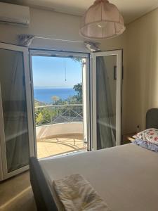 a bedroom with a bed and a view of the ocean at Mikro Amoni Beach Villa in Pefkali