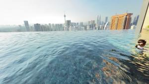 吉隆坡THE LUCENTIA SUITES by LUXURY的在一个城市的背景中游泳的人