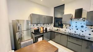 a kitchen with a stainless steel refrigerator and a wooden table at Beachfront Colombo 03 Bed Apartment in Colombo