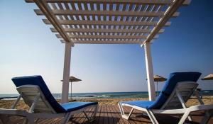 a group of chairs and umbrellas on a beach at Sea view and Aqua park Apartments at Caesar Blue Complex in Iskele +9 photos