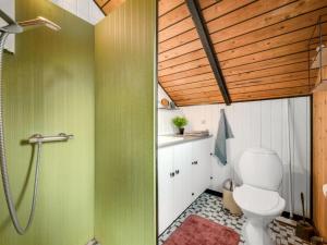 a bathroom with a toilet and a wooden ceiling at Holiday Home Tjana - 6km from the sea by Interhome in Esbjerg +14 photos