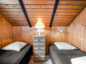 two twin beds in a room with wooden walls at Holiday Home Tjana - 6km from the sea by Interhome in Esbjerg